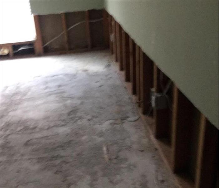 drywall flood cut 2 feet high around the room with green walls and concrete floor and an air mover
